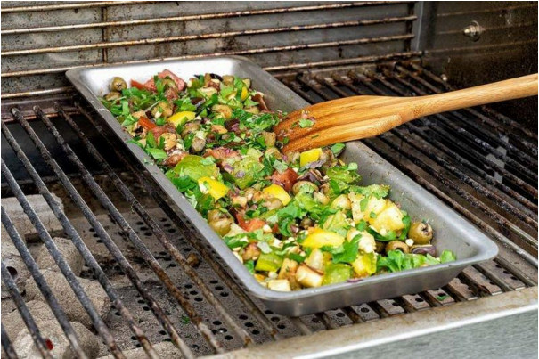 Gemüse in einer Grillschale zur besseren Zubereitung auf einem Holzkohlegrill