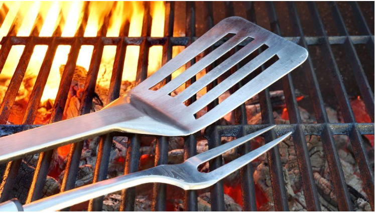 Holzkohlegrill Tipps - Ein Holzkohlegrill von Schickling mit glühender Holzkohle und Grillbesteck auf dem Rost