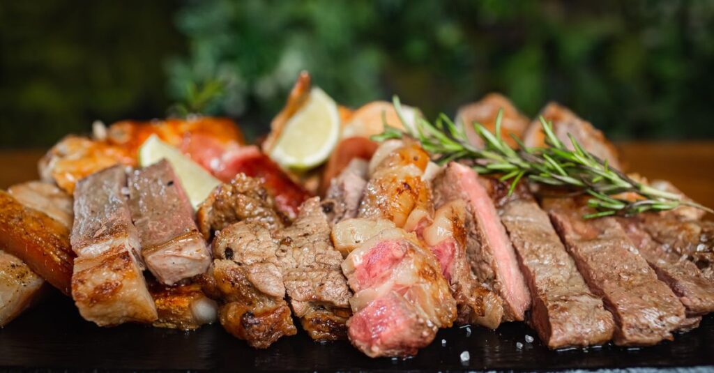 Verschiedene Fleischstücke wie Steak und Wurst für den Grill